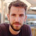 Photo de Guillaume Denoel, il a uen légère barbe. Il a les cheveux chatain et regarde l'objectif en souriant.